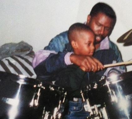 Young Travis Scott practicing drum with his musician father